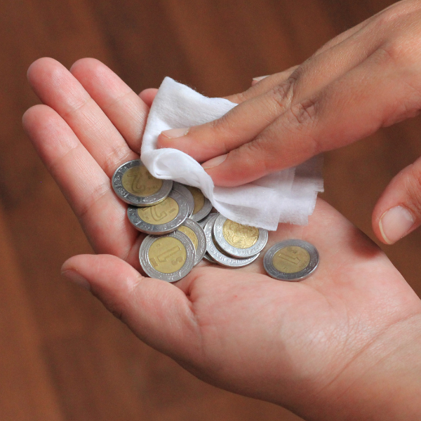 Someone wiping coins in their hand with cloth