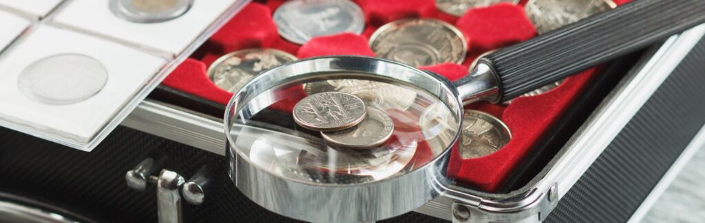 coins in a storage box with a magnifying glass