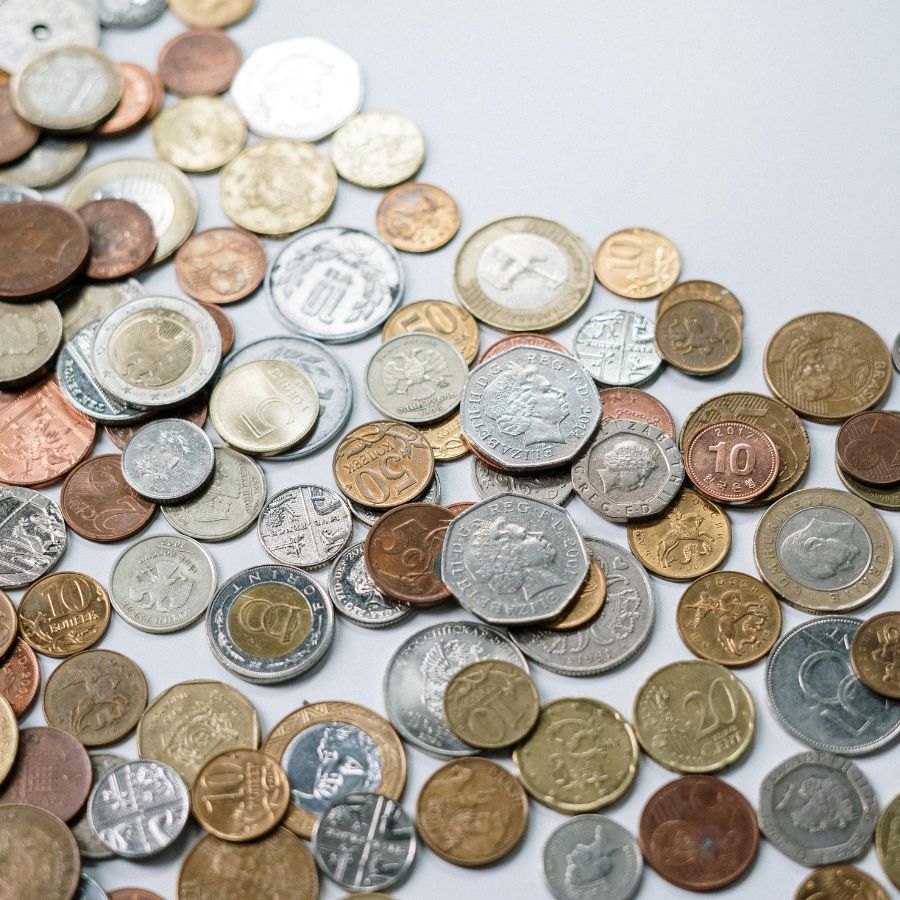 A stack of international coins on a white background