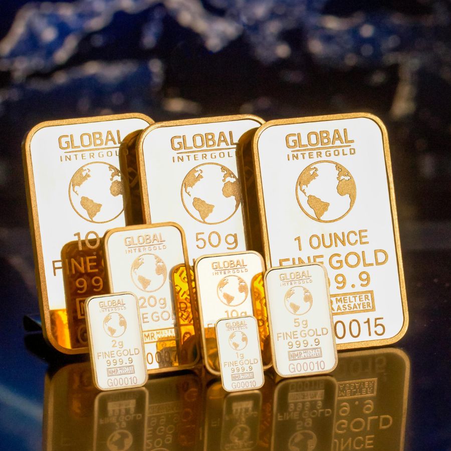 A stack of gold bullion bars shown against a globe
