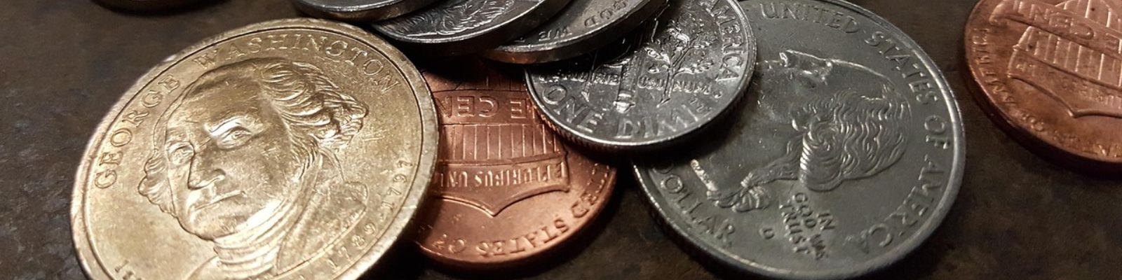  Pennies, nickels, dimes, and quarters on a concrete background